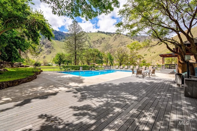 view of swimming pool with a deck with mountain view