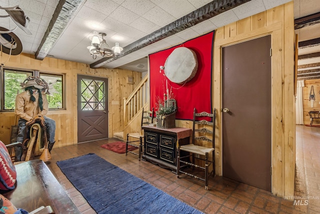 interior space with wood walls and a chandelier