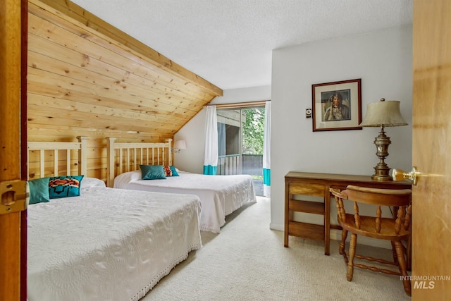 carpeted bedroom featuring wooden walls, a textured ceiling, lofted ceiling, and access to exterior