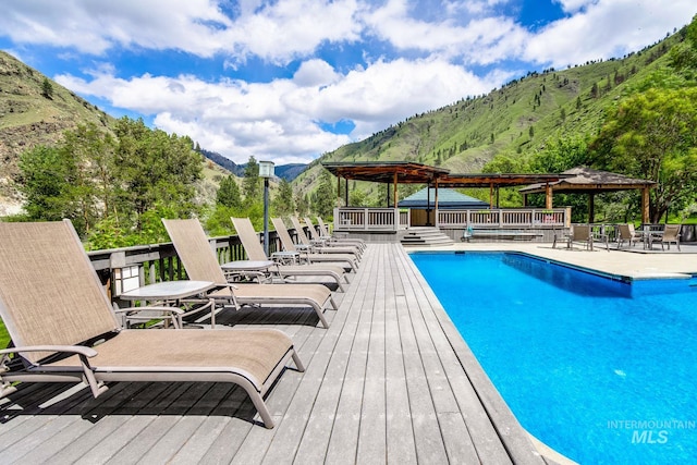 view of swimming pool featuring a deck with mountain view and a gazebo