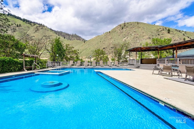 view of pool with a mountain view and a patio area