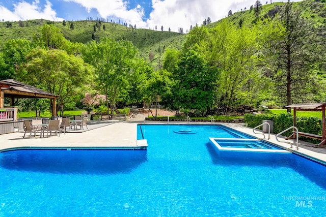 view of swimming pool featuring a patio and a gazebo