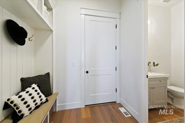 mudroom featuring baseboards, dark wood finished floors, and visible vents