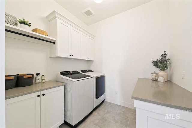laundry area featuring light tile patterned floors, independent washer and dryer, visible vents, baseboards, and cabinet space