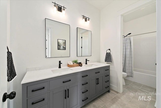 full bath featuring toilet, double vanity, a sink, and shower / tub combo with curtain