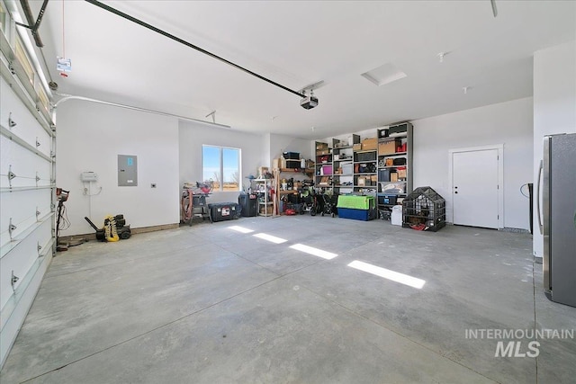 garage featuring a garage door opener, freestanding refrigerator, and electric panel