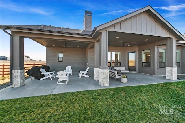 rear view of house featuring a yard, a ceiling fan, a patio area, fence, and a chimney