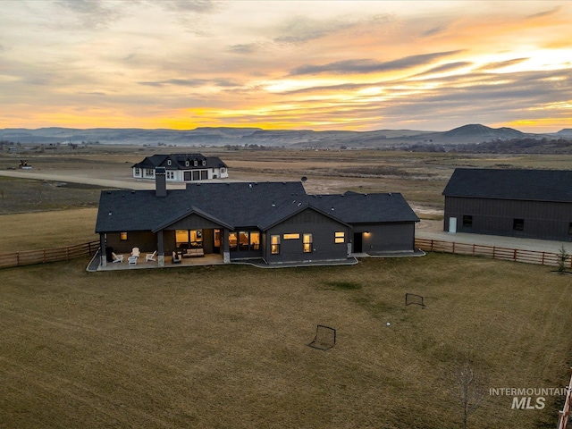 back of house featuring a mountain view, fence, and a patio
