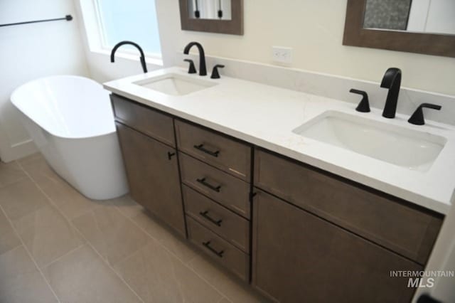 bathroom with vanity, tile patterned floors, and a washtub