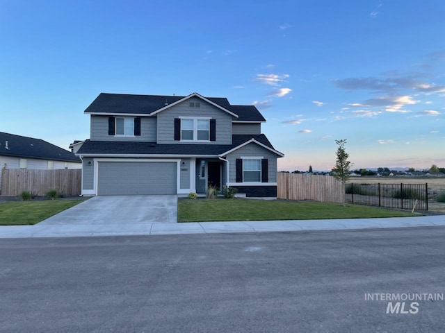 view of front of property featuring a garage and a lawn