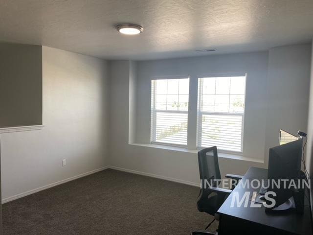 office featuring a textured ceiling and dark colored carpet