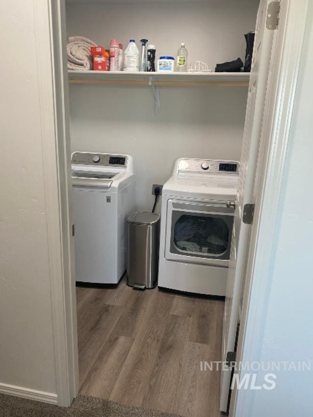 laundry room with separate washer and dryer and hardwood / wood-style floors