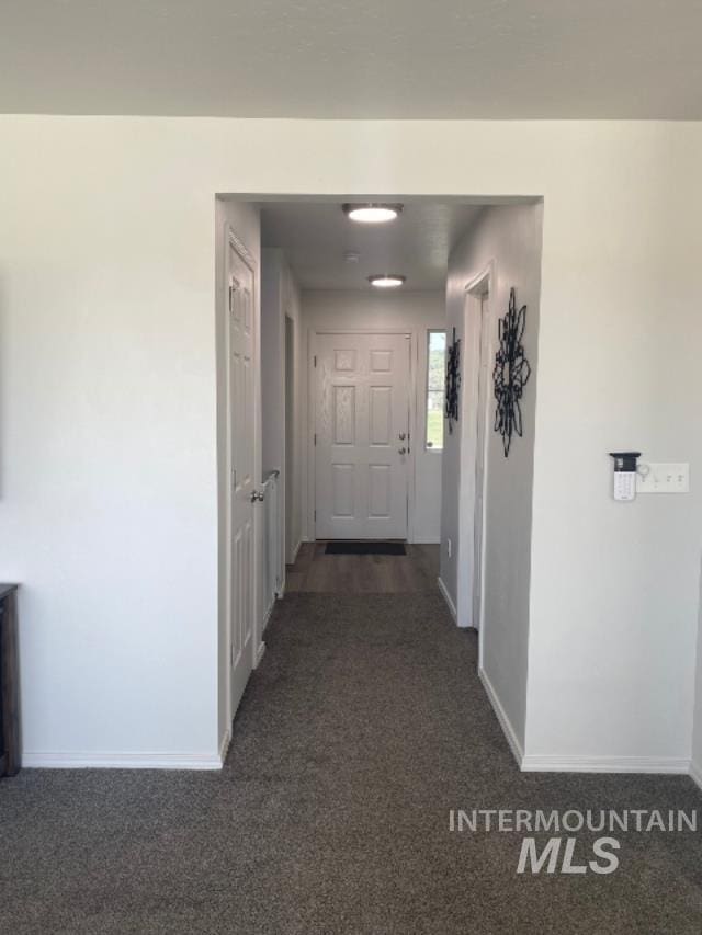 corridor featuring dark colored carpet