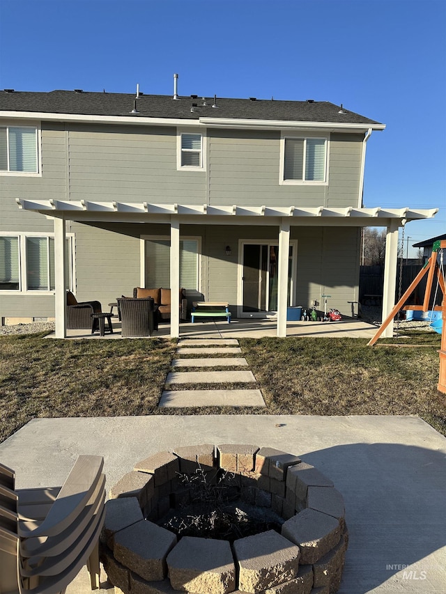 back of house with a playground, a patio area, and an outdoor living space with a fire pit