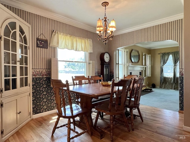 710 Locust St, Twin Falls, ID 83301 - dining room featuring ornamental molding, wallpapered walls, arched walkways, a chandelier, and light wood-style floors
