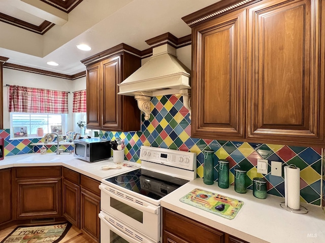 710 Locust St, Twin Falls, ID 83301 - kitchen with white range with electric cooktop, stainless steel microwave, crown molding, light countertops, and premium range hood