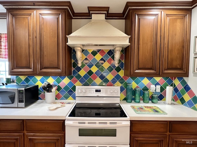 710 Locust St, Twin Falls, ID 83301 - kitchen with white range with electric cooktop, stainless steel microwave, custom range hood, backsplash, and ornamental molding