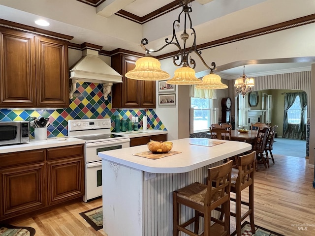 710 Locust St, Twin Falls, ID 83301 - kitchen featuring double oven range, stainless steel microwave, premium range hood, light wood-style floors, and light countertops