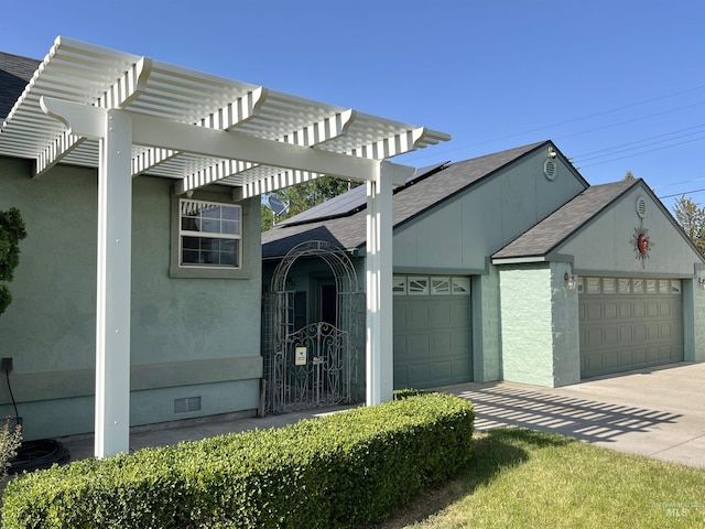 710 Locust St, Twin Falls, ID 83301 - view of home's exterior featuring roof mounted solar panels, a garage, a pergola, a shingled roof, and concrete driveway