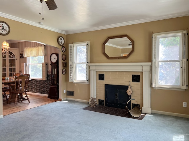 710 Locust St, Twin Falls, ID 83301 - living room featuring carpet, arched walkways, ceiling fan, ornamental molding, and a brick fireplace