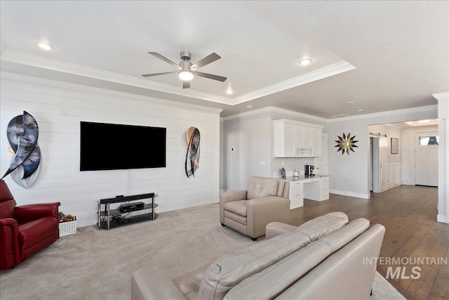 living room featuring hardwood / wood-style flooring, ceiling fan, and ornamental molding