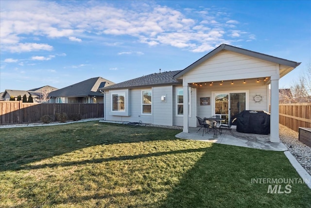 back of house featuring a patio area and a lawn