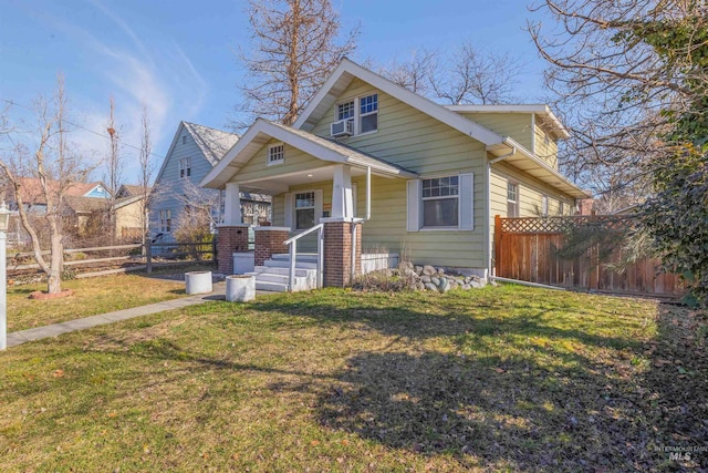 bungalow featuring a porch, a front yard, and fence