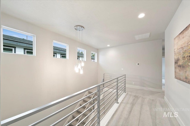 hallway featuring plenty of natural light and light colored carpet