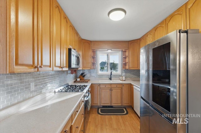 4320 N Locust Grv, Meridian, ID 83642 - kitchen featuring backsplash, appliances with stainless steel finishes, light wood-type flooring, a sink, and light countertops