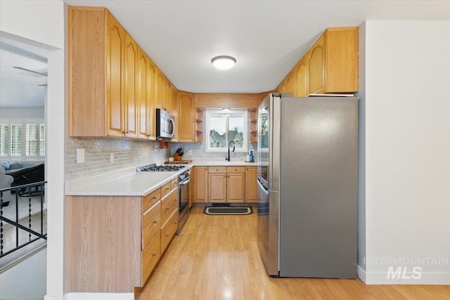 4320 N Locust Grv, Meridian, ID 83642 - kitchen with a sink, appliances with stainless steel finishes, backsplash, and light wood-style flooring