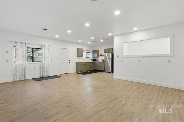 4320 N Locust Grv, Meridian, ID 83642 - unfurnished living room featuring baseboards, recessed lighting, and light wood-style flooring