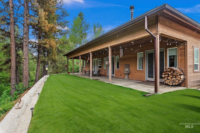 rear view of house featuring a patio area and a lawn