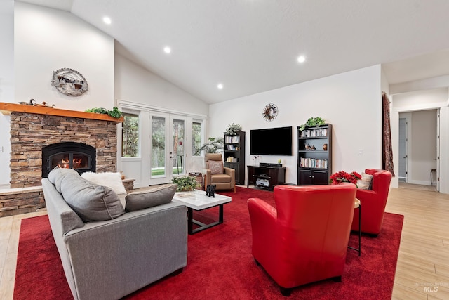 living room with hardwood / wood-style floors, a fireplace, high vaulted ceiling, and french doors