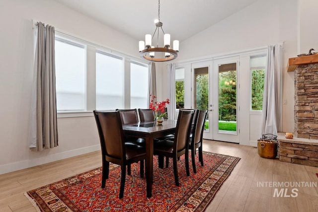 dining room with vaulted ceiling, a notable chandelier, and light wood-type flooring