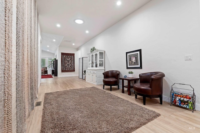 living area with lofted ceiling and light hardwood / wood-style flooring