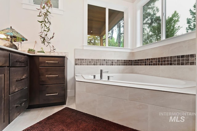 bathroom with tile patterned flooring and a relaxing tiled tub