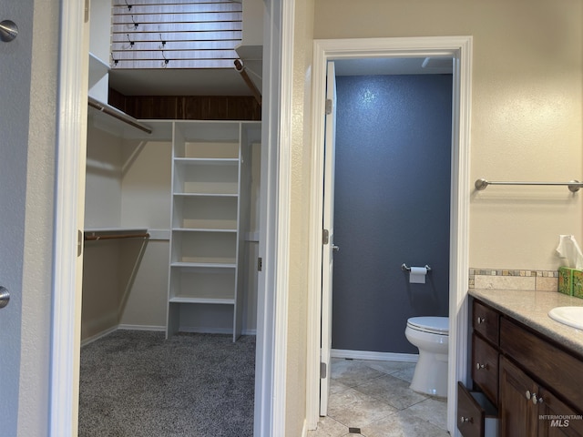 bathroom featuring tile patterned flooring, vanity, and toilet