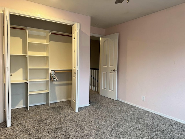 unfurnished bedroom featuring dark carpet, a closet, and ceiling fan