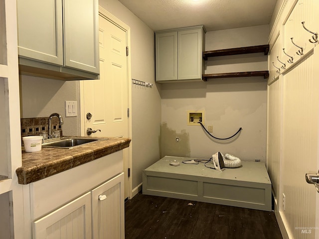 washroom featuring cabinets, sink, hookup for a washing machine, dark hardwood / wood-style floors, and a textured ceiling