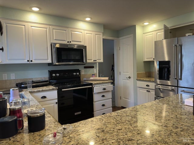 kitchen featuring white cabinets, appliances with stainless steel finishes, and light stone counters