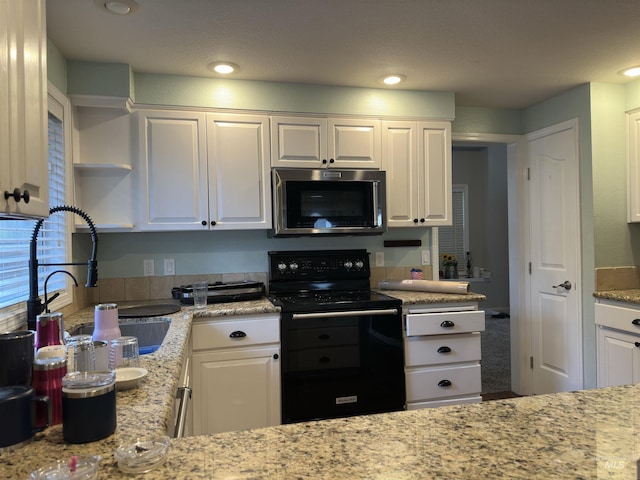 kitchen featuring black electric range and white cabinets