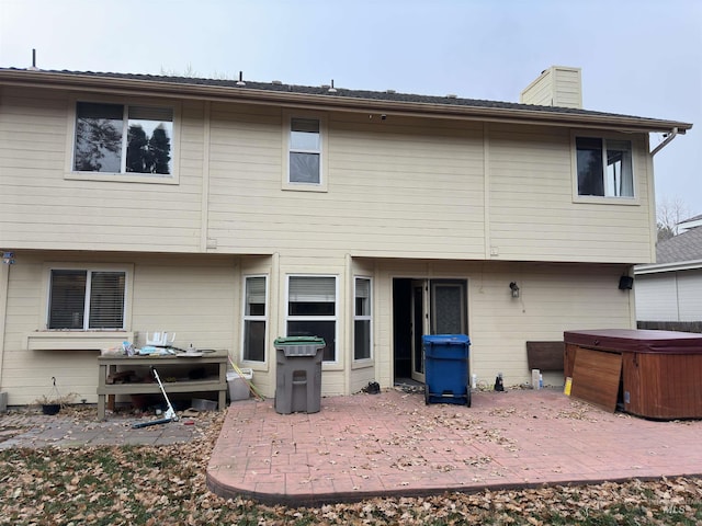 back of house with a patio and a hot tub