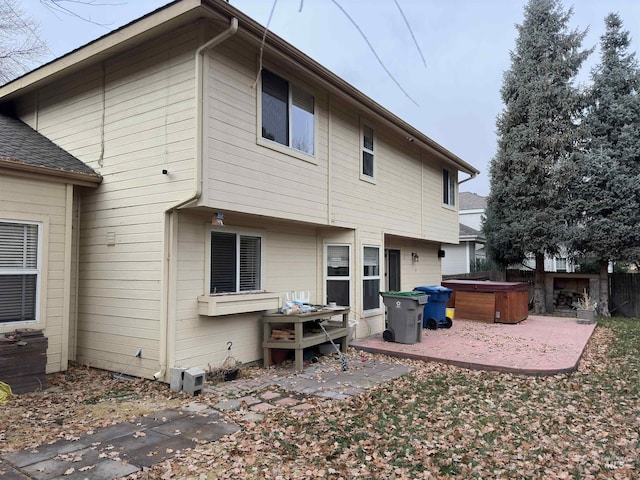 back of property with a patio and a hot tub