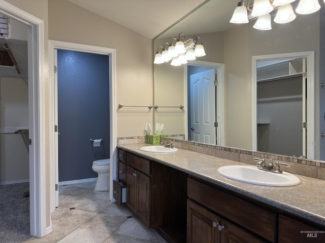 bathroom with tile patterned flooring, vanity, vaulted ceiling, and toilet