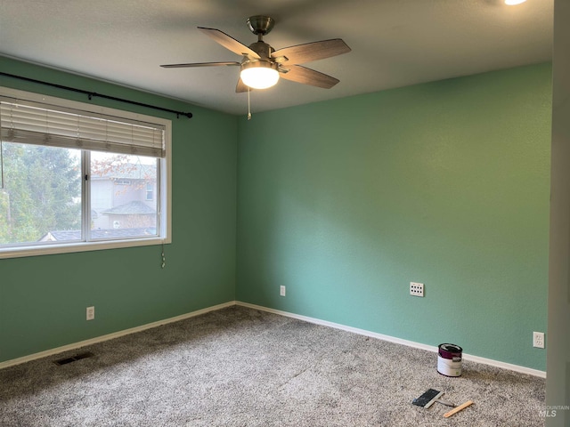 carpeted spare room with ceiling fan