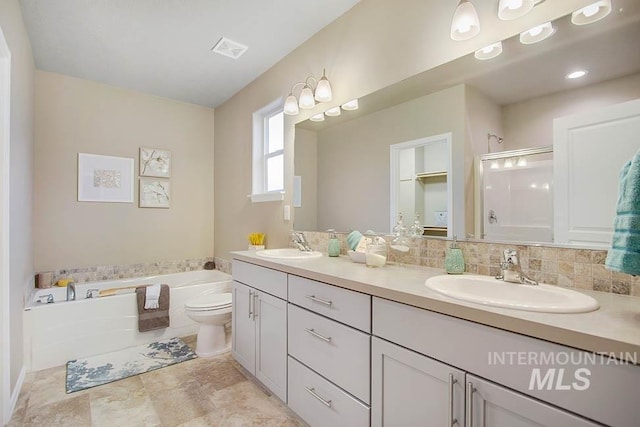 full bath featuring a stall shower, a garden tub, double vanity, and toilet