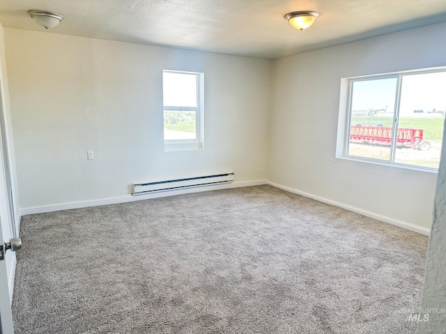 empty room featuring a baseboard radiator, carpet, and a textured ceiling