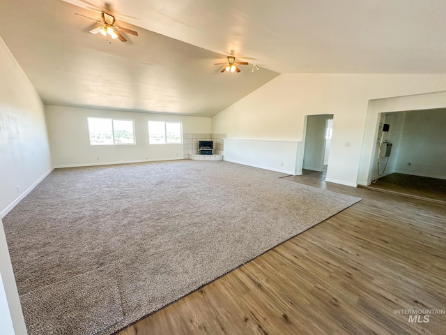 unfurnished living room featuring lofted ceiling, wood-type flooring, a fireplace, and ceiling fan