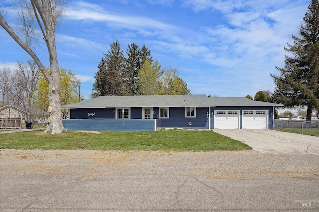 ranch-style house with concrete driveway, an attached garage, fence, and a front yard
