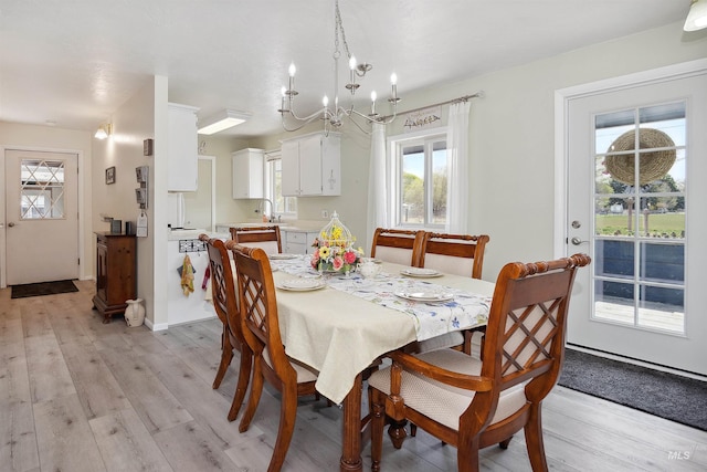 dining space featuring a chandelier and light wood finished floors